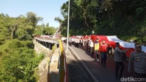 Polres Sumedang membentangan Bendera Merah Putih sepanjang 1 kilometer di sepanjang jalan bersejarah, Jalan Cadas Pangeran, Jumat, 15 Agustus 2025. (Dwiky Maulana Vellayati)