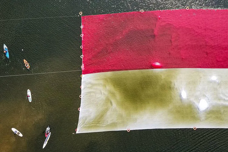 Pembentangan bendera merah putih berukuran 45 x 45 meter di Danau Situ Gintung, Ciputat, Tangerang Selatan (Tangsel), Minggu (17/8/2025). (Dok.Istimewa)